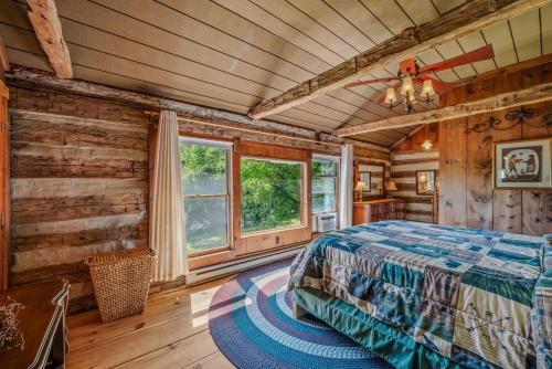 a bedroom with a bed in a room with wooden walls at Pondview Cabin - Rustic Log Style Home, Grill, Wifi, Screen Porch, Trail, View, Pond Access, King Bed in Morton Grove
