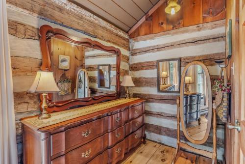 a dressing room in a log cabin with a mirror at Pondview Cabin - Rustic Log Style Home, Grill, Wifi, Screen Porch, Trail, View, Pond Access, King Bed in Morton Grove
