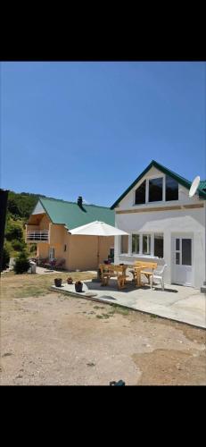 a house with a picnic table and an umbrella at Jezerina in Šavnik