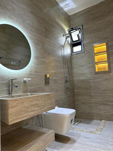 a bathroom with a toilet and a sink and a mirror at أستراحة الهوني in Banghāzī