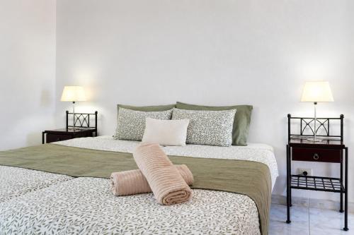 a bedroom with two beds with pillows and two lamps at Bright House, Pool & Workspace near Medano Beach in El Médano