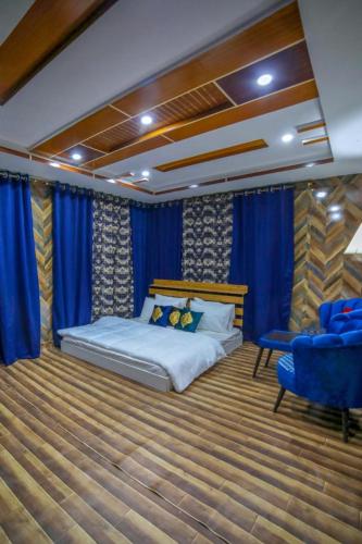 a bedroom with a bed and a blue chair at Royal Brangsa in Skardu