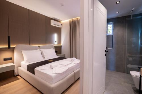 a bedroom with a bed and a bathroom at WG Hotel Lake View in Ksamil