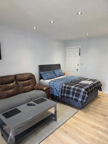 a living room with a couch and a bed at Detached Flat in Leeds, Free WIFI and parking, Pool table, 75 inch tv, Netflix in Moortown