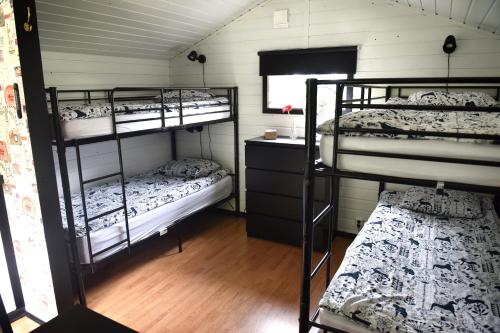 a room with three bunk beds and a desk at B&B Olsegården in Tvååker