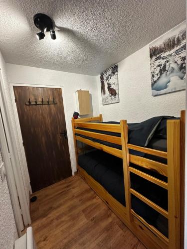 a bedroom with a wooden bunk bed with a door at Chalet Puy-Saint-Vincent m from slopes in Puy-Saint-Vincent
