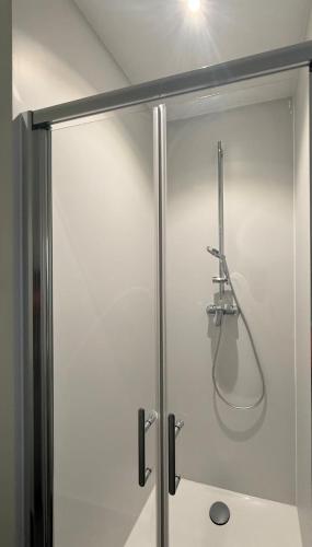 une douche dans une salle de bain avec un tuyau dans l'établissement The2C, à Godshuis