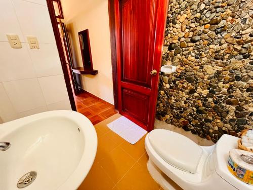 a bathroom with a white sink and a toilet at Hosteria Chuquitos - Chalupas in Tena