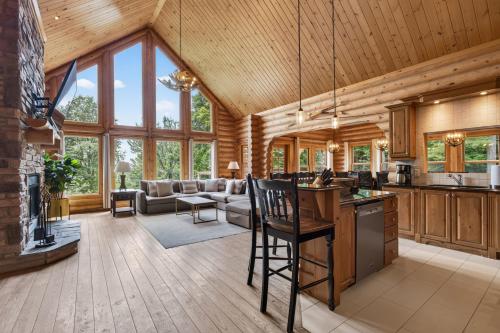 an open kitchen and living room in a log cabin at Fiddler Lake Resort - Elk 96 in Mille-Isles