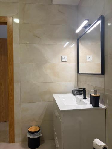 a bathroom with a sink and a mirror at Alojamento das cantarinhas in Bragança