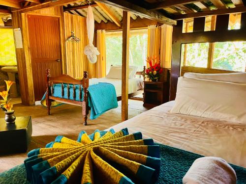 a bedroom with a large bed and a room with a bed sqor at Hosteria Chuquitos - Chalupas in Tena