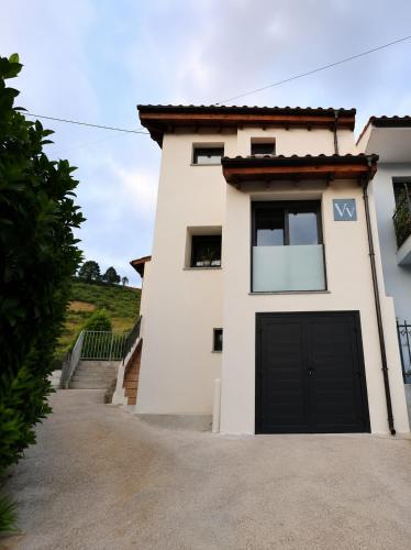a white house with a black garage at MC Vega- Mi Casina con vistas al mar in Ribadesella