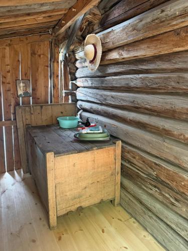 a kitchen in a log cabin with a table and a hat at Vetleberget - simple living in Vaga