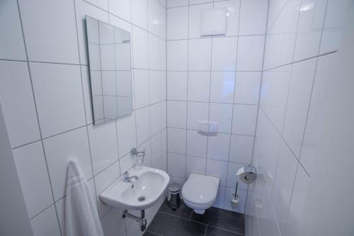 a white bathroom with a sink and a toilet at Appart Gastauer in Sankt Gallenkirch