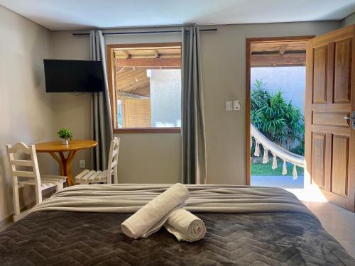 a bedroom with a bed with two towels on it at Morada Carmem in Praia do Rosa