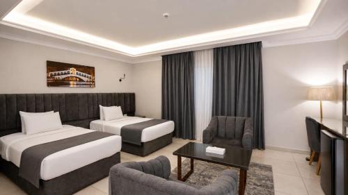 a hotel room with two beds and a couch at Grand Plaza Hotel New Giza in Kafr Abū ʼumaydah