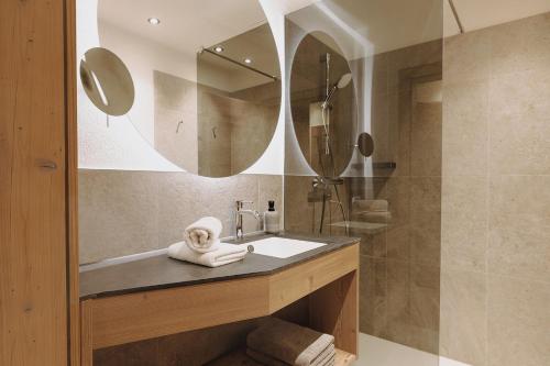 a bathroom with a sink and a mirror at Erlenhof Appartements in Grossarl