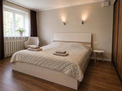 a bedroom with a bed with two towels on it at Town Square Apartment in Panevėžys