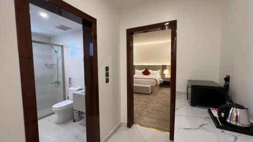a hotel room with a bathroom with a bed and a mirror at Eioraa Hotel فندق إيوراء in Khamis Mushayt