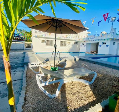a table and chairs with an umbrella next to a pool at Hostel Treebu in Valladolid