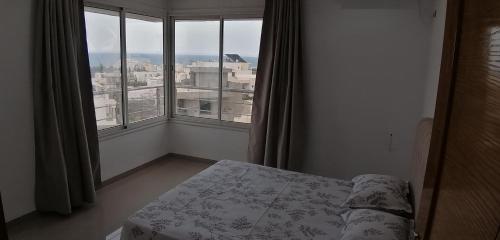 a bedroom with a bed and a large window at Résidence familiale le corail de chat Meriem in Sousse