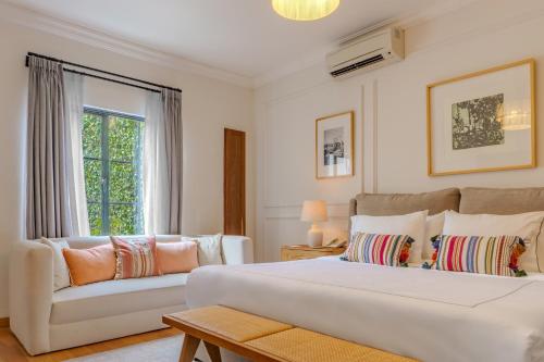 a white bedroom with a large bed and a couch at Hotel Villa Condesa in Mexico City