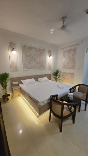 a bedroom with a bed and a chair and a table at Modern Studio With Balcony & Raod Facing View in Noida