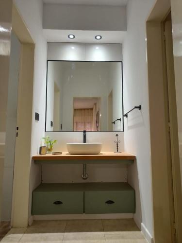a bathroom with a sink and a large mirror at Petit Margaret in Santa Rosa