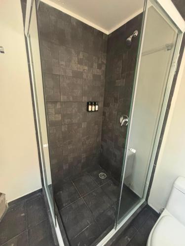 a bathroom with a shower with a glass door at Lol-ha glamp in Temixco