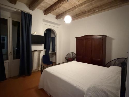 a bedroom with a white bed and a wooden cabinet at Casa Ela in Serra San Bruno