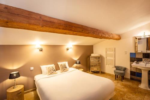 a bedroom with a large white bed and a sink at Mas Du Pont Rouge in Sylvéréal