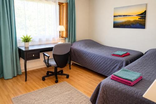 a room with a bed and a desk and a bed and a chair at Nordic City Home in Lahti
