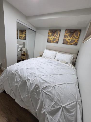 a bedroom with a bed covered in a white comforter at Ope suites Winnipeg in Winnipeg