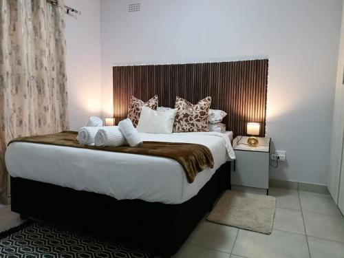 a bedroom with a large bed with pillows at Your Exclusive PMB Escape in Pietermaritzburg