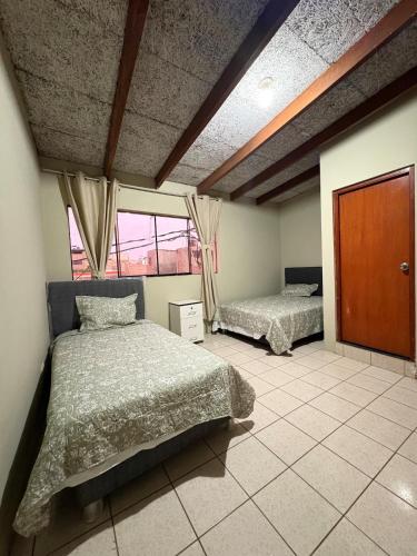 a bedroom with two beds in a room at CIX HOUSE, Casa completa de 3 pisos in Chiclayo