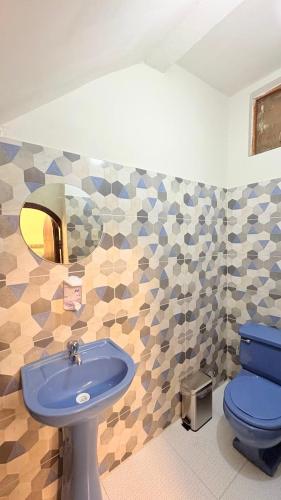 a bathroom with a blue toilet and a sink at CIX HOUSE, Casa completa de 3 pisos in Chiclayo