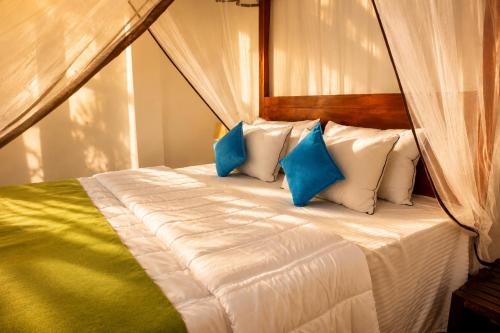a bedroom with a bed with blue and white pillows at Greenland Villa Ella in Ella