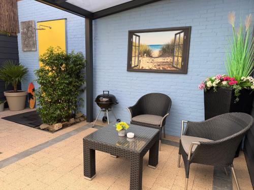 a patio with chairs and a table and a mirror at Bed & Wellness Chinel Luxe vakantiehuis met Sauna's en Bubbelbad in Sint Annaland