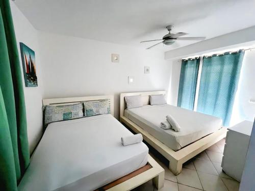two twin beds in a room with a window at Hotel Bloom Garden Beach Punta Cana in Punta Cana