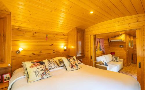 a bedroom with a bed in a wooden cabin at Le Pont Rouge Roulotte in Sylvéréal