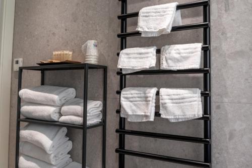 a towel rack with white towels in a bathroom at Hotel Vivit ***S in Mestre