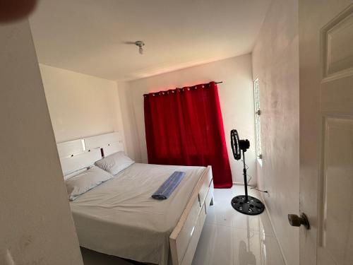 a bedroom with a bed with a red curtain at Palmera africana 1 in Los Paredones