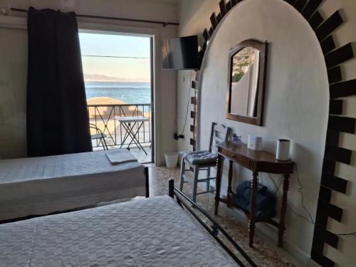 a bedroom with a bed and a table and a window at Salamina Sea View in Kakí Vígla