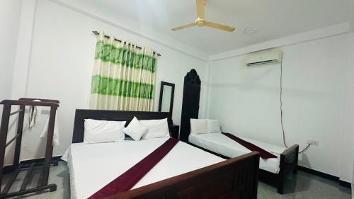 a bedroom with a bed and a ceiling fan at Nilaveli Beach Haven in Nilaveli
