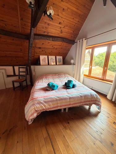 a bedroom with a bed with blue towels on it at Longère 'Nature et Baies' in Montigny