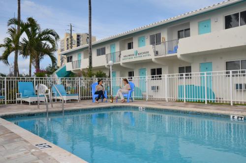 a woman and a child sitting next to a swimming pool at Hollywood Beachside Boutique Suite in Hollywood