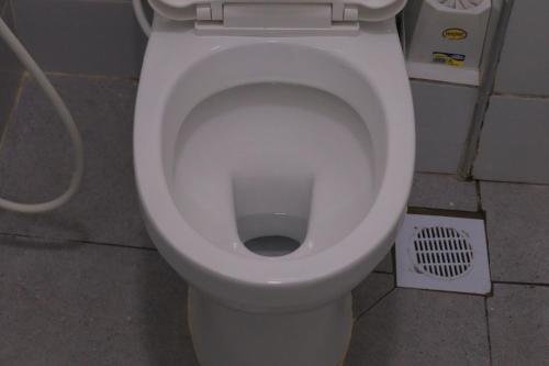 a white toilet in a bathroom with a drain at Soft stay homes in Mombasa