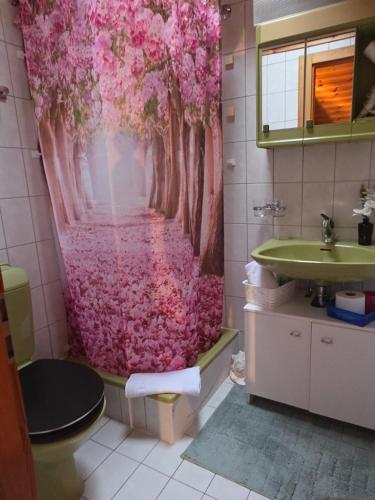a bathroom with a pink shower curtain and a sink at Duplex Salgesch in Salgesch