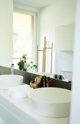 a bathroom with a white sink and a mirror at ALMMONTE LIGNUM - Premium Lodge in Wagrain