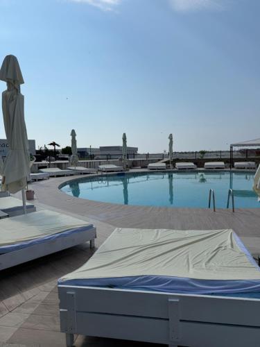 a swimming pool with a bed and an umbrella at Palace Resort in Venus